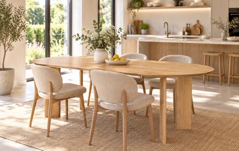 Massief eiken eettafel met houten tafelpoten en vier stoelen in een lichte Scandinavische keuken