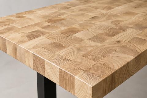 Massief essen kops houten tafelblad met zichtbaar blokpatroon en zwarte tafelpoot
