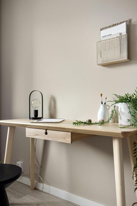 Licht houten bureau met lade en taps toelopende houten tafelpoten in een stijlvol interieur