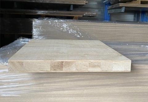 Massief houten kopshoutpaneel met zichtbare blokken, liggend op verpakte houten panelen