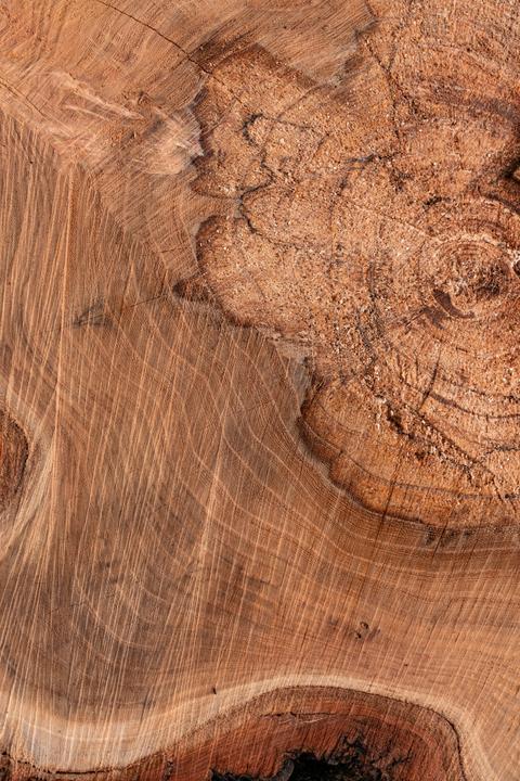Detail van massief acaciahout met warme houtnerf, noesten en natuurlijke scheuren