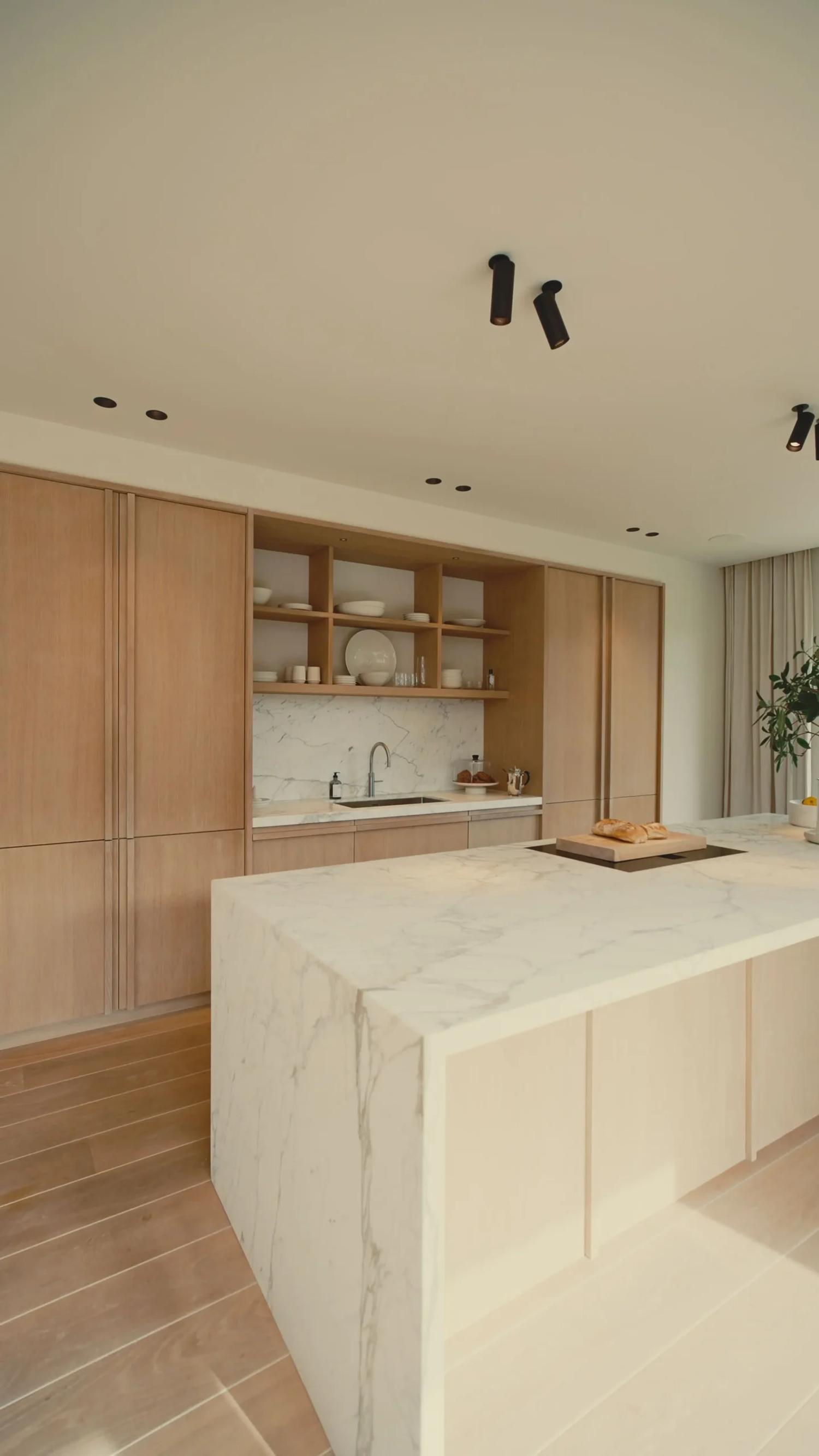 Moderne keuken met hoge houten kasten, open wandplanken en een ruim marmeren kookeiland