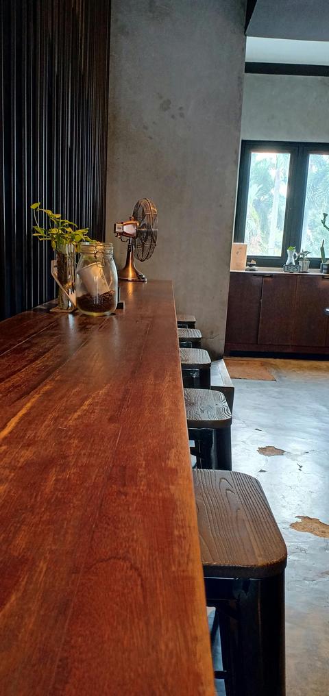 Massief acacia tafelblad met doorgaande lamellen als lange bartafel in een modern interieur